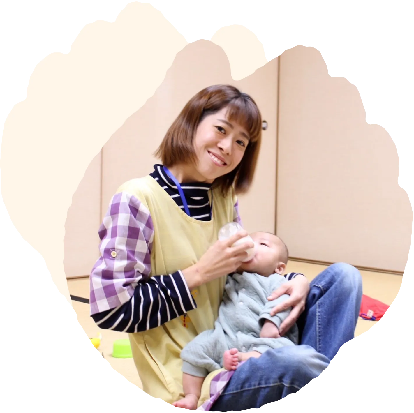 てっての保育士が、赤ちゃんを優しく抱っこしている託児の風景。